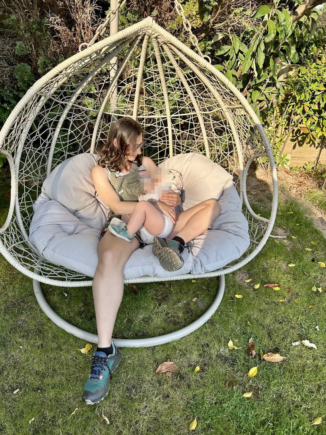 Scarlet breastfeeding her baby in the garden